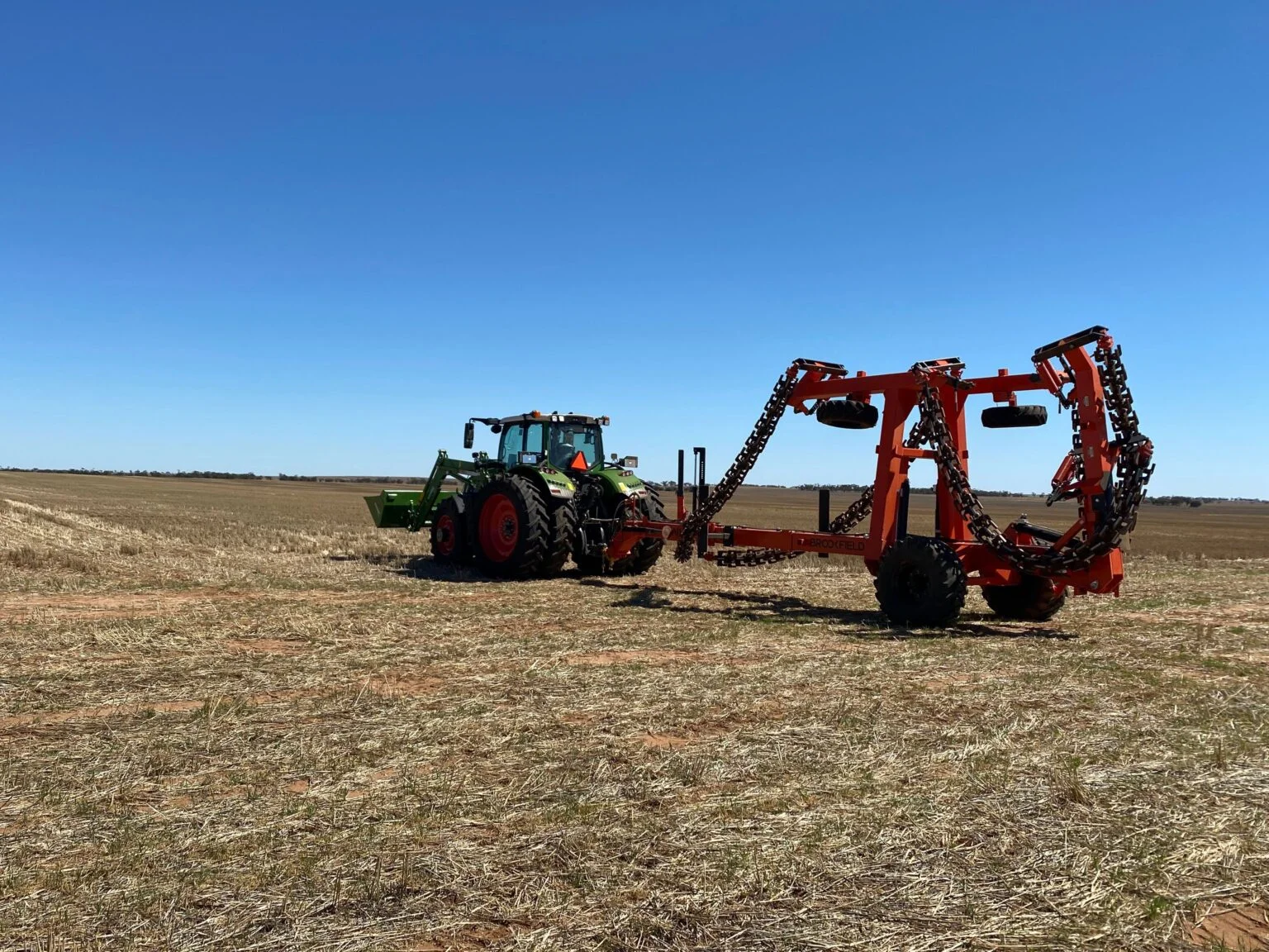 A BROOKFIELD ChainBar working a paddock behind a tractor